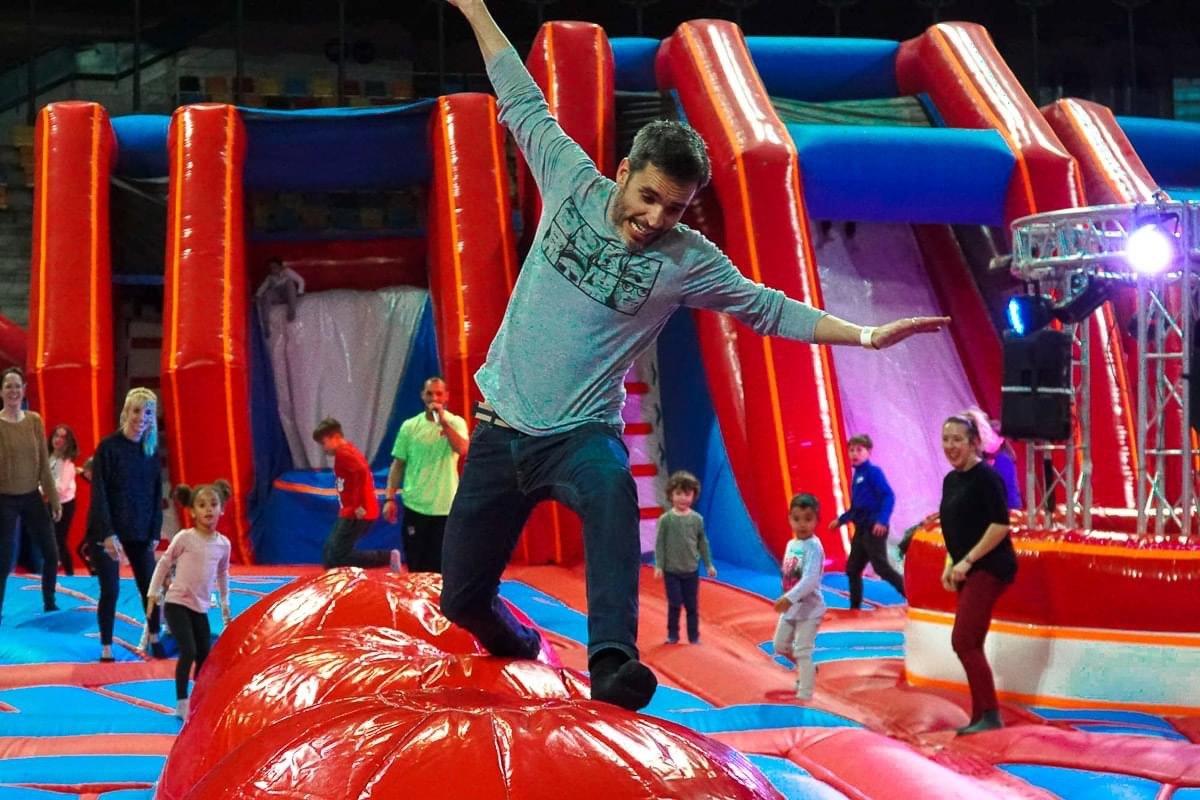 Indoor-Park mit großen Luftkissen, springenden Kindern und Erwachsenen